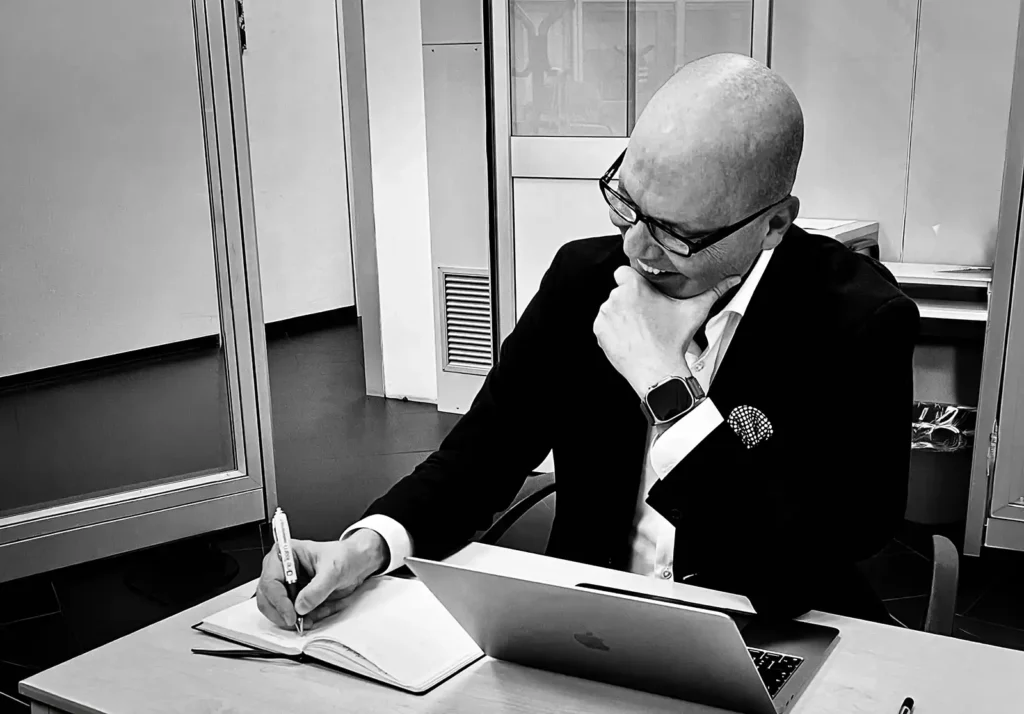 Massimo Marucci alla scrivania mentre scrive una riflessione sulla nuova visione della telefonia aziendale come infrastruttura strategica.